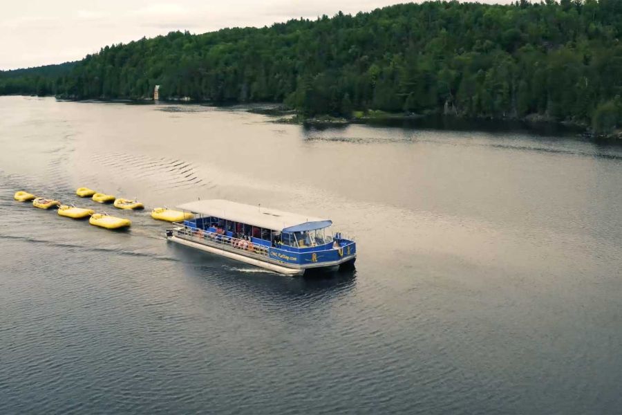 De boot van Owl Rafting Resort trekt rafts door de Ottawa River in Ontario in Canada.