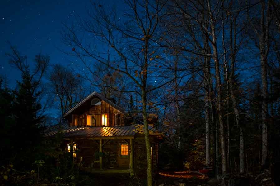 Buiten aanzicht van de Algonquin Log Cabin na zonsondergang in Ontario in Oost-Canada.