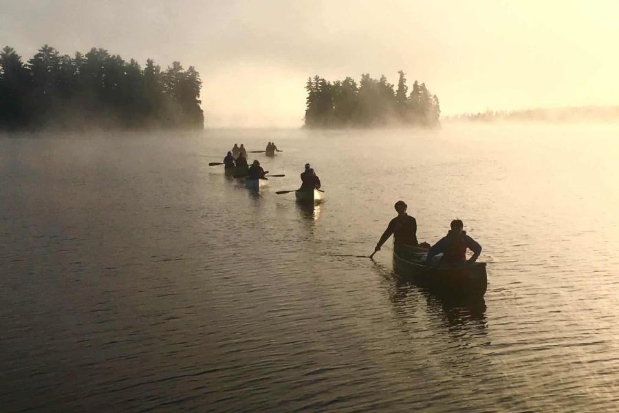 Gasten van de Algonquin Log Cabin varen in kano�s over het water in Algonquin Pronvicial Park in Canada.
