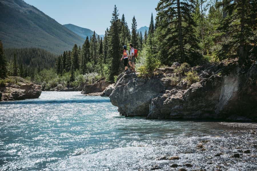 Wandelaars langs een rivier in de Rocky Mountains in Alberta in Canada.
