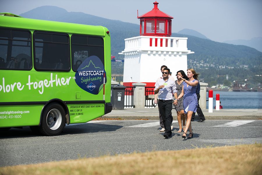Passagiers naast een bus tijdens een Hop-On Hop-Off tour in Vancouver in Canada,
