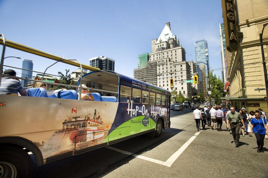 Bus rijdt door Vancouver tijdens een Hop-On Hop-Off tour in British Columbia.