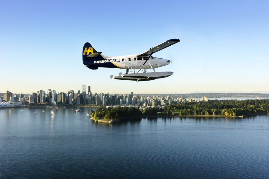 Watervliegtuig vliegt buiten Vancouver met de skyline op de achtergrond in Canada.