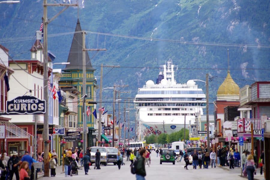 Een straat in Skagway in Alaska met een cruiseschip op de achtergrond.