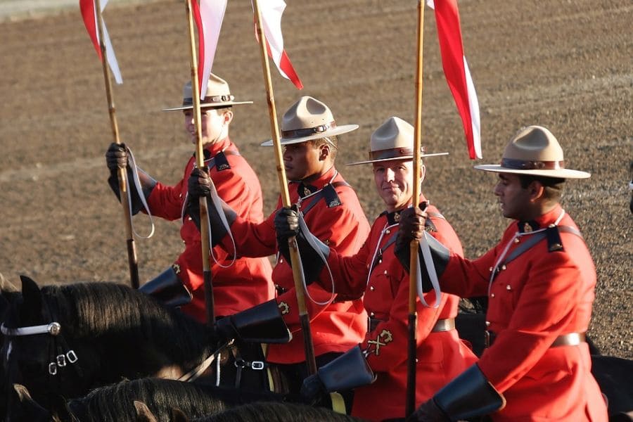 Vier agenten van de Royal Canadian Mounted Police in uniform op paarden.