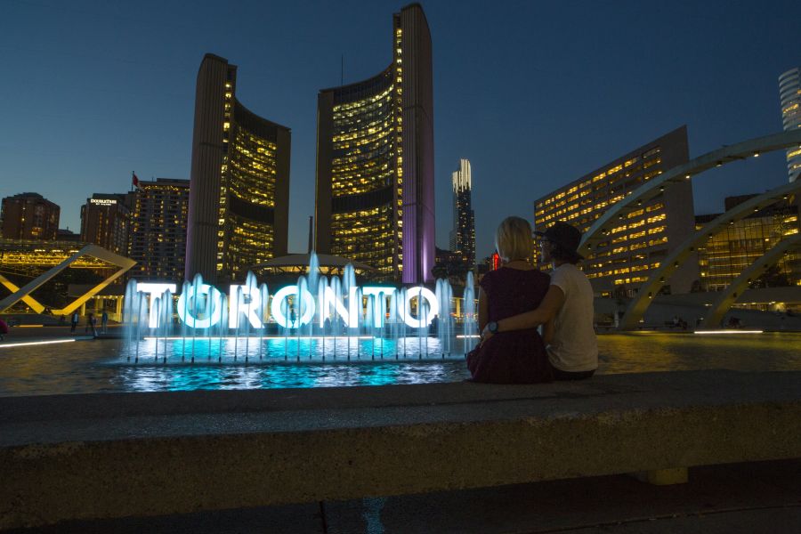 Twee mensen voor de Toronto Sign in Ontario in Canada.