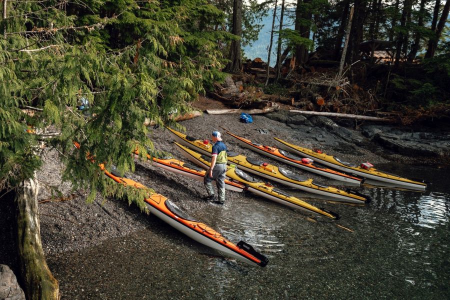 Kajaks op het strand tijdens een kajak tocht langs de kust van Vancouver Island in Canada.