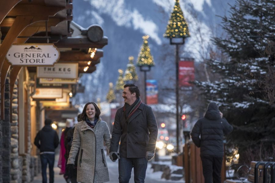 Stel loopt over Banff Avenue tijdens winterreis in Canada