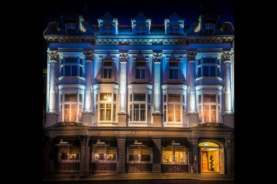 Voorkant van het Bishop`s Gate Hotel in Derry in het donker met verlichting dat schijnt op het gebouw