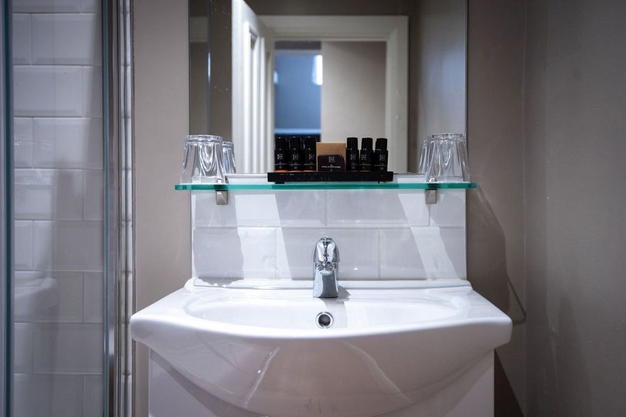 Een badkamer met uitzicht op de wastafel in het Bishop`s Gate Hotel in Derry