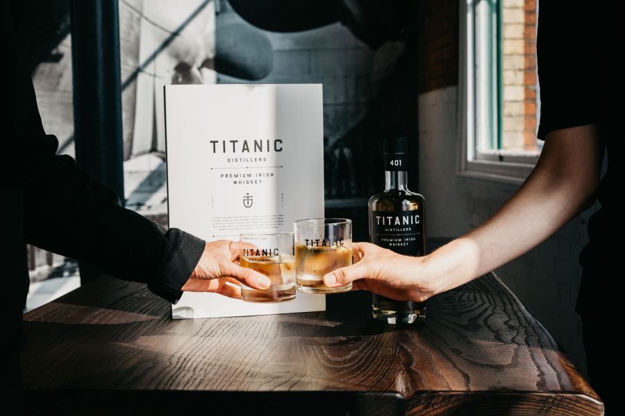Twee mensen proosten met een glas whiskey