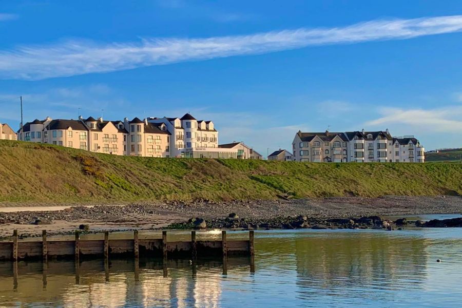 Achterkant van het hotel met uitzicht op het water en de steiger die aan de kust ligt