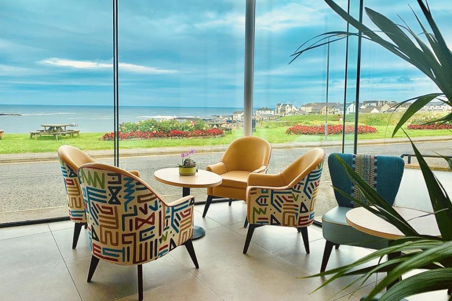 Een zithoek in het Bayview Hotel in Bushmills met uitzicht op de oceaan