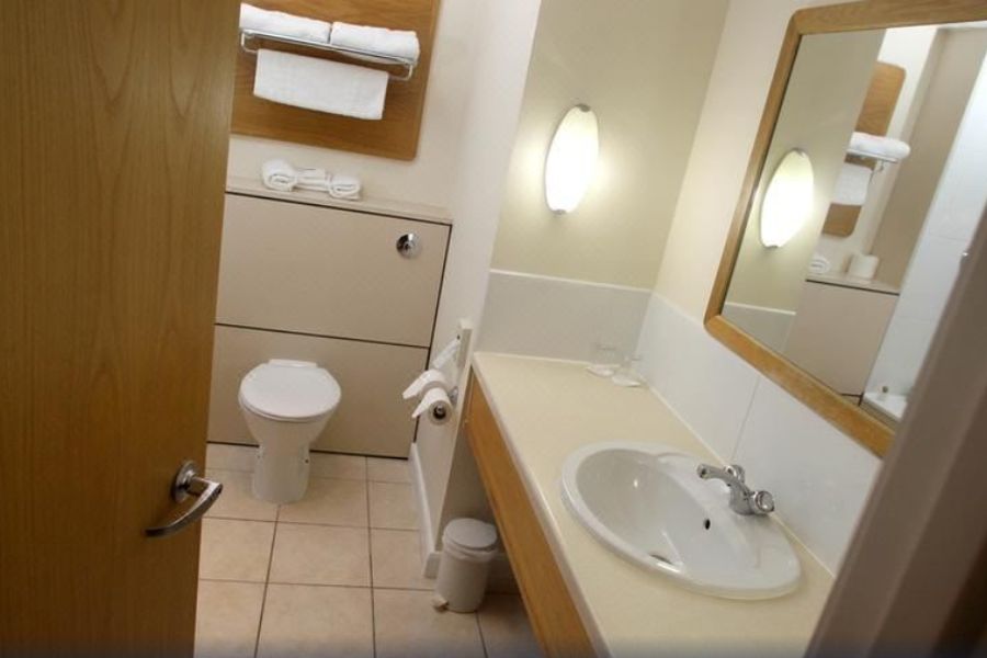 De standaard badkamer in het Bayview Hotel in Bushmills met uitzicht op de wastafel en toilet