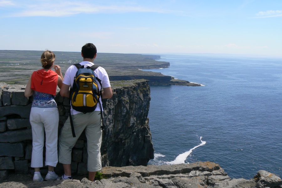 Twee hikers met uitzicht op de kliffen van de Burren