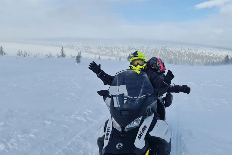 Twee blije mensen op een sneeuwscooter