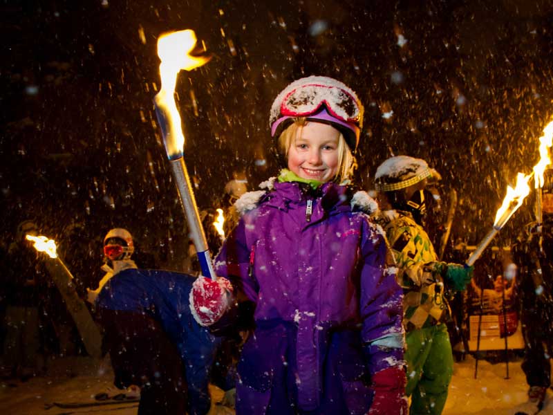 Fakkeltocht tijdens het sneeuwen in de avond