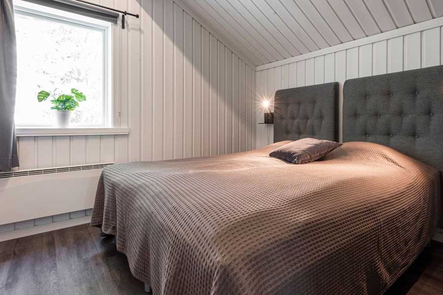 Slaapkamer met een tweepersoonsbed in een Bruna Byn chalet in Sälen